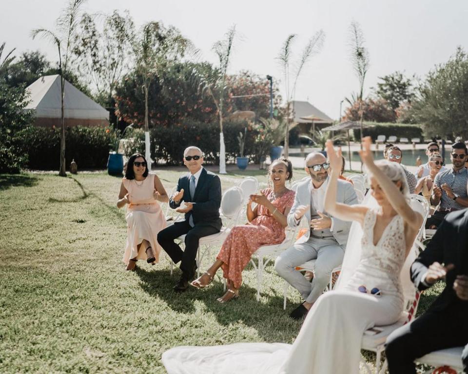 Eine Gruppe von Menschen, die auf einer Hochzeit auf Stühlen sitzen in der Unterkunft Les jardins d isis in Marrakesch