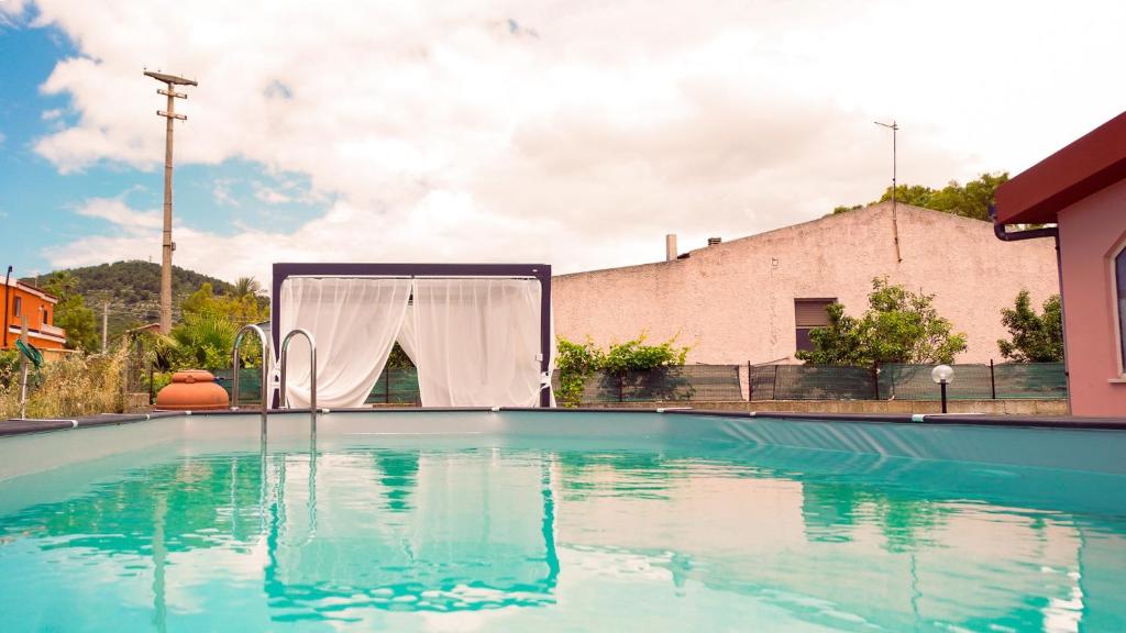 una piscina con tenda al centro di PM Villa Arenosu Guest House a Fertilia