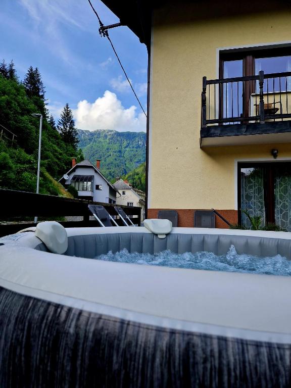 a bath tub with a waterfall in front of a house at House Utrinek with free play room, jacuzzy and garage in Podbrdo