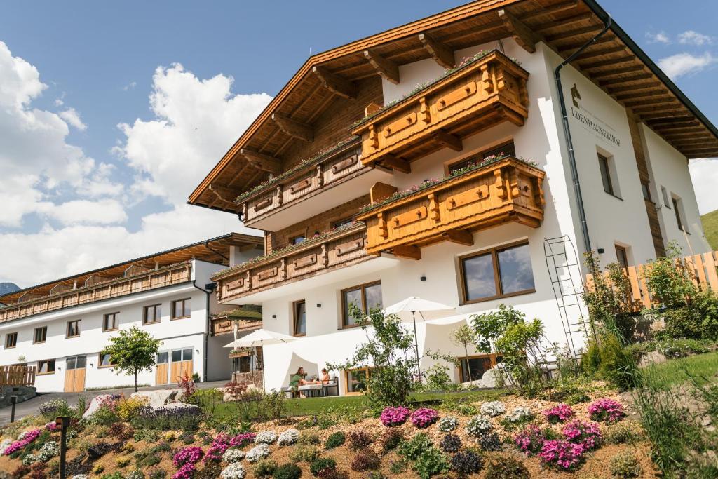 un bâtiment avec des fleurs dans les montagnes dans l'établissement Edenhauserhof, à Innsbruck