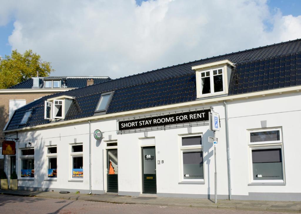 een wit gebouw met een bord waarop staat dat stoomkamers te huur zijn bij Short Stay Wageningen in Wageningen