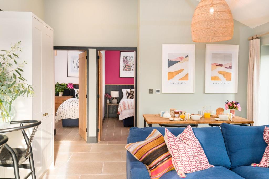 a living room with a blue couch and a table at Appletree - a newly converted luxury barn in Warwickshire on our farm in Evesham