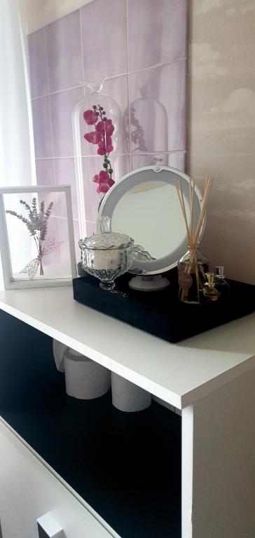 un estante blanco con un espejo y fotos en él en Maison chaleureuse avec charme d'ancien, en Jablines