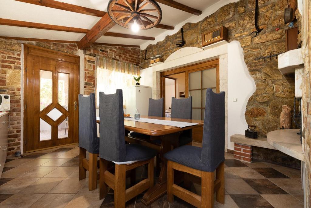 una sala da pranzo con tavolo in legno e sedie blu di Holiday house Hana a Rovigno (Rovinj)
