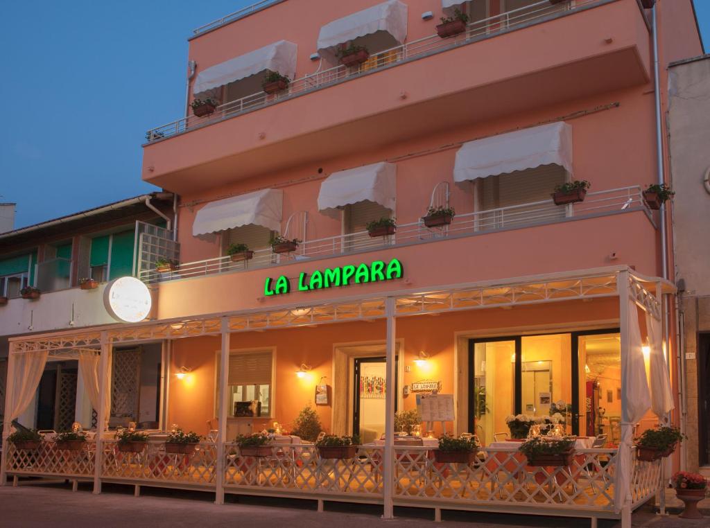 a pink building with a sign that reads la la lavapa at Albergo La Lampara in Marina di Cecina