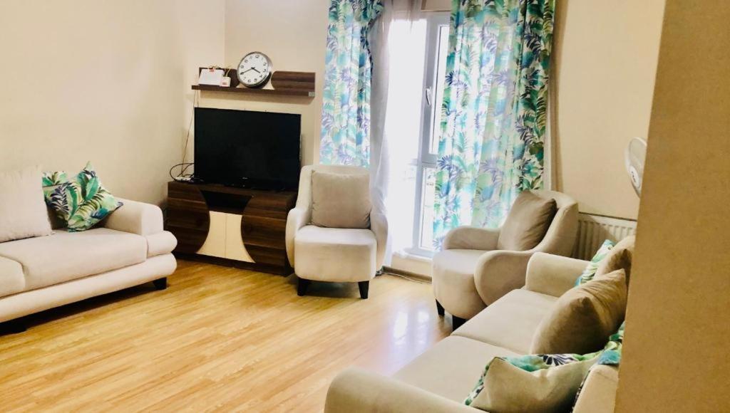 ein Wohnzimmer mit einem Sofa, Stühlen und einem TV in der Unterkunft Full 2 bedroom apartment in luxury complex in Esenyurt
