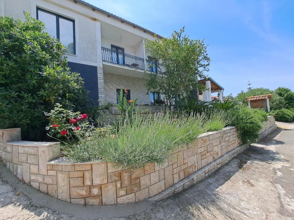 a brick retaining wall in front of a house at Guesthouse Tamara in Lovište