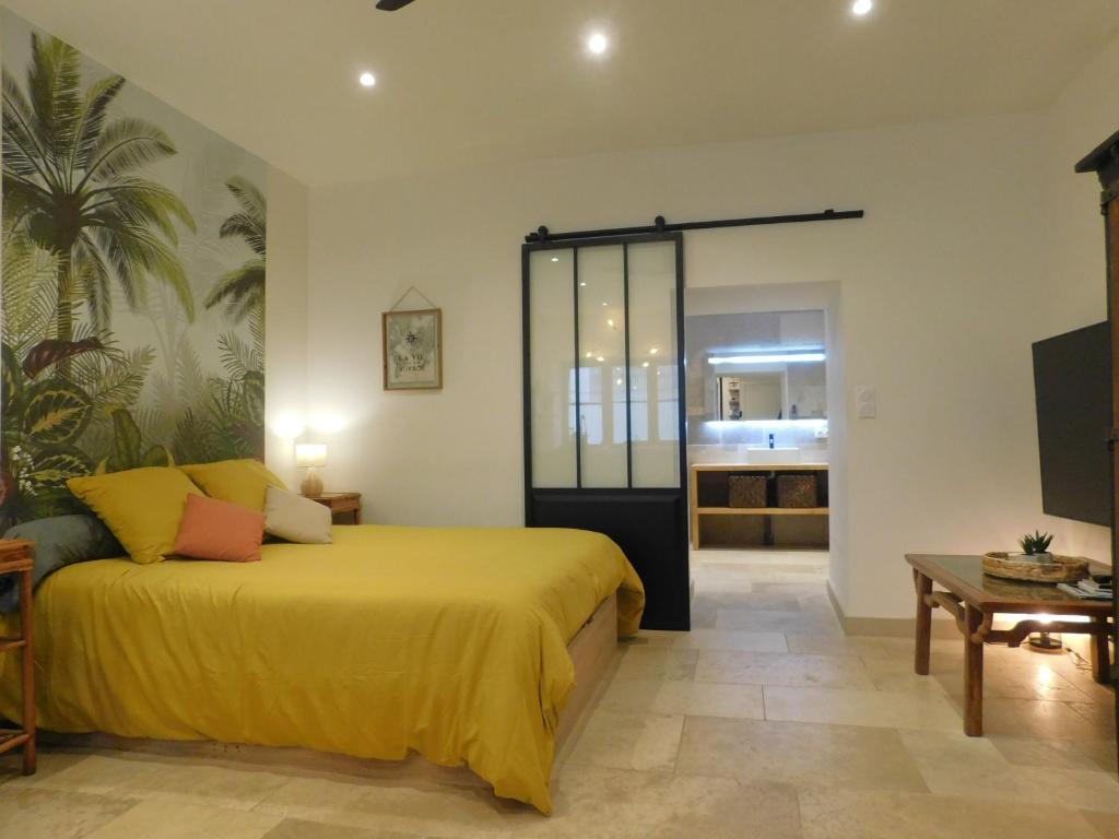 a bedroom with a yellow bed and a living room at Studio Calme Hyper Centre Brive in Brive-la-Gaillarde