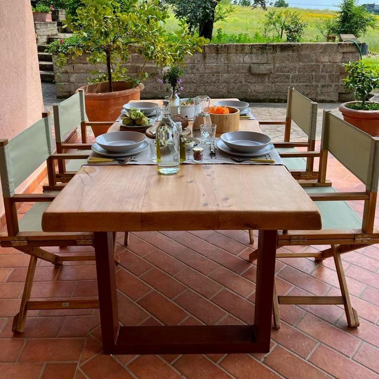 a wooden table with plates and utensils on a patio at Casetta Valmora in Valpiana