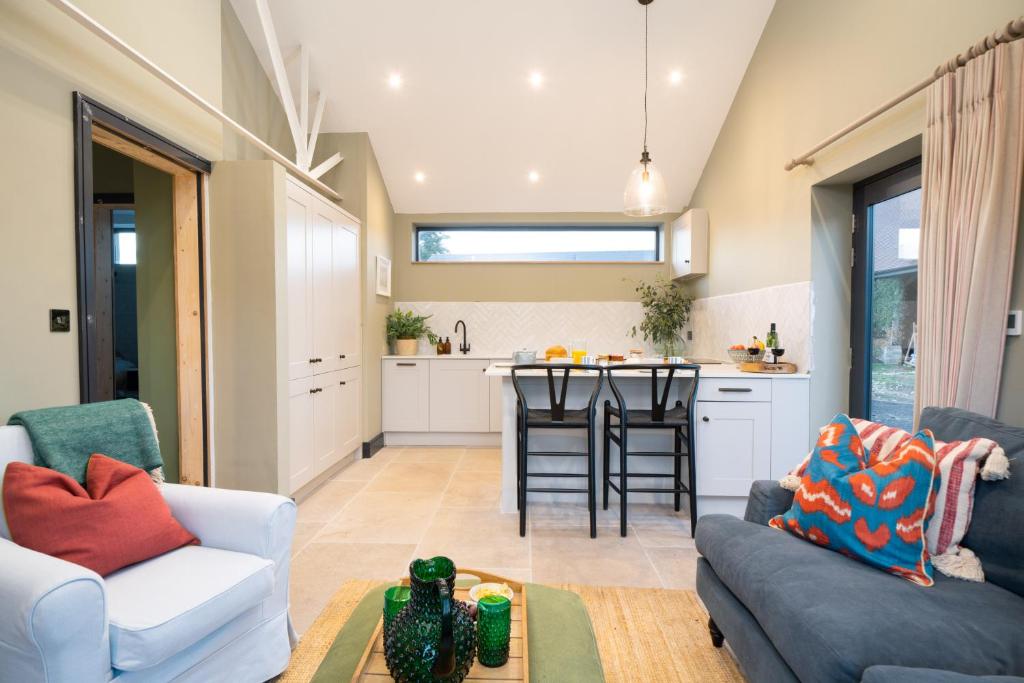 a living room with a couch and a table at Hailes - a newly converted barn on our farm between Stratford upon Avon and the Cotswolds in Evesham