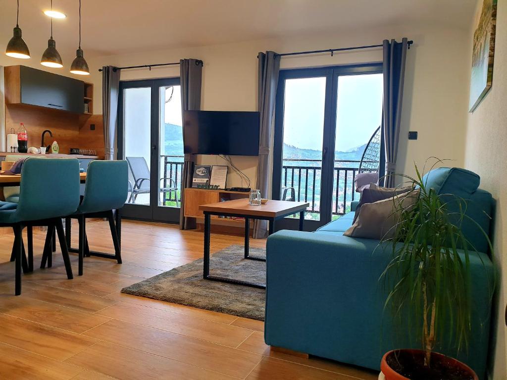 a living room with a blue couch and a table at Apartmani Višegradski pogled in Višegrad