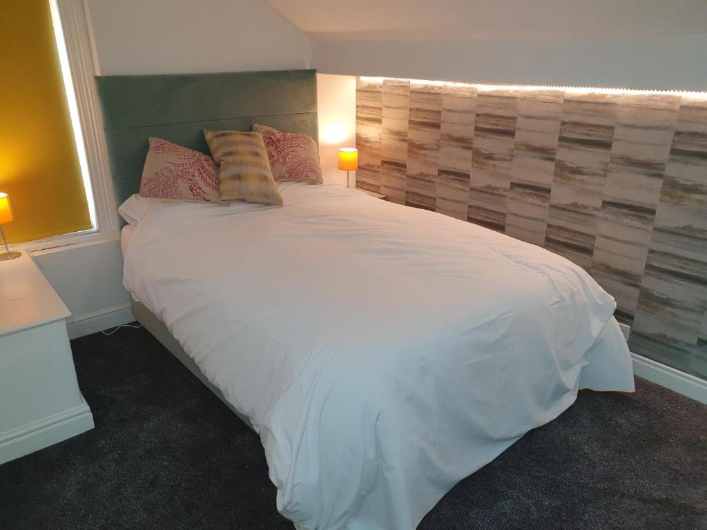 1 dormitorio con 1 cama blanca grande y 2 almohadas en Lyndene House, en Huddersfield