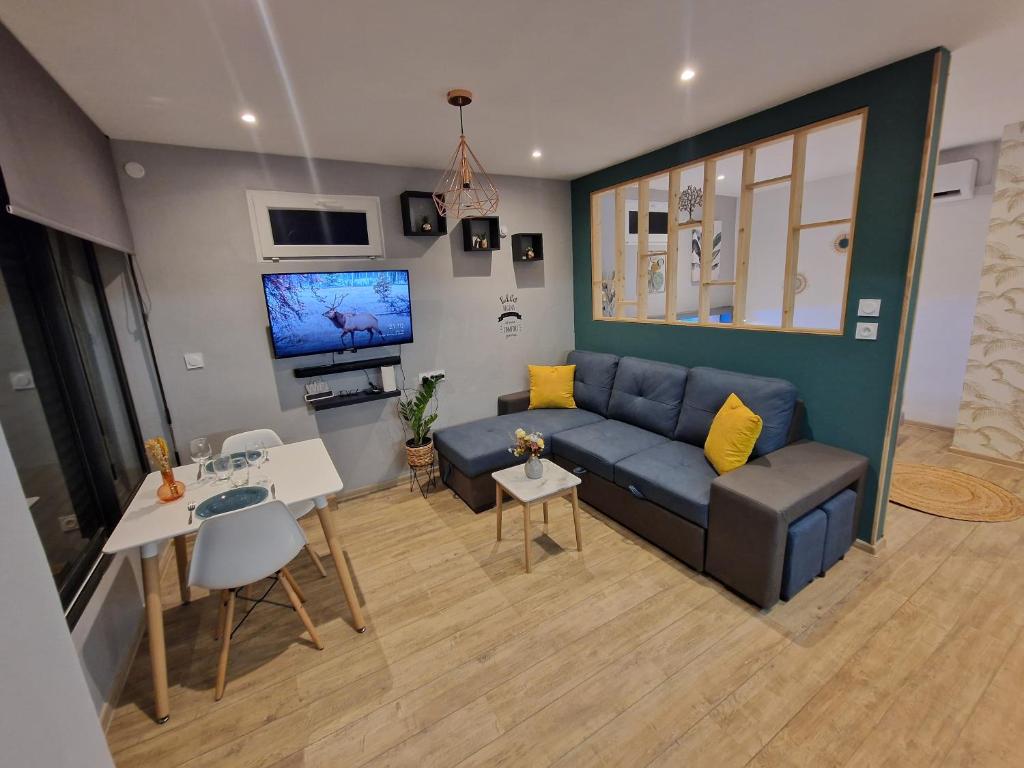 uma sala de estar com um sofá azul e uma televisão em Le Platinium Barachois em Saint-Denis
