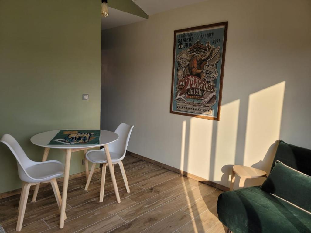 Zimmer mit einem Tisch, Stühlen und einem Sofa in der Unterkunft Air marin in La Bernerie-en-Retz