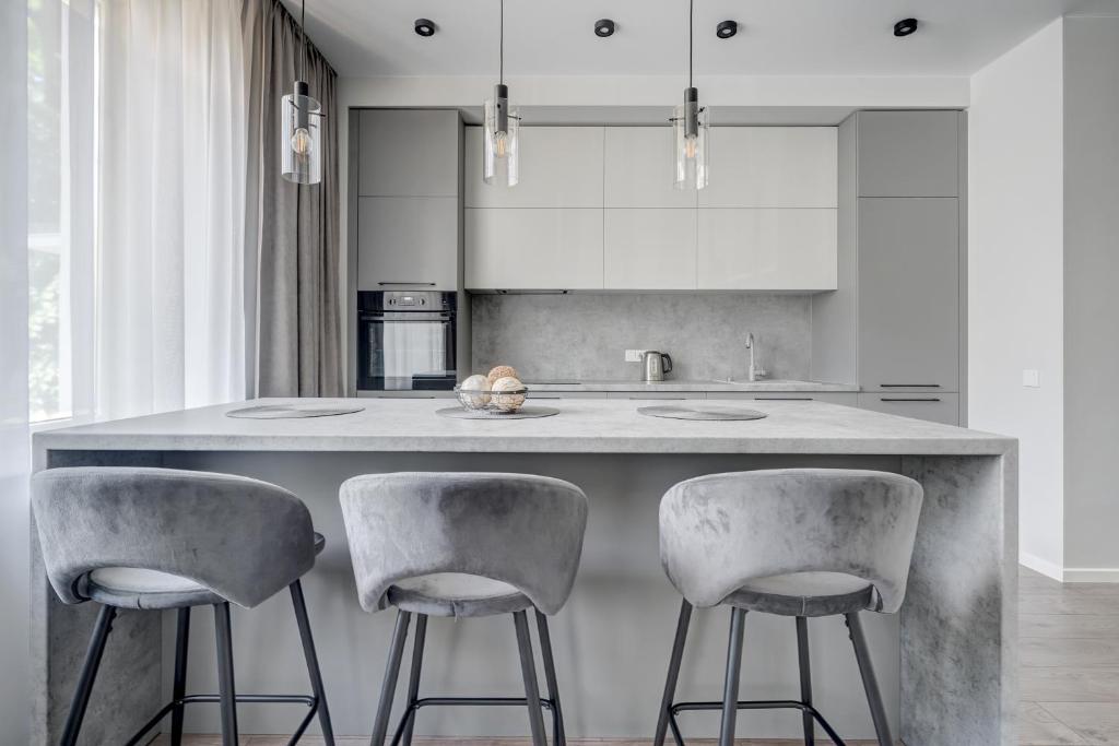 a kitchen with a large counter with two stools at KALVARI APARTMENTs in Vilnius