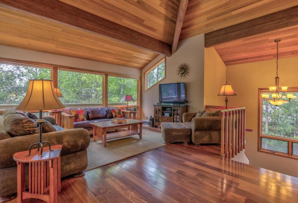 a living room with wood ceilings and a living room with furniture at Tan Oak - Unit 37 in Sunriver