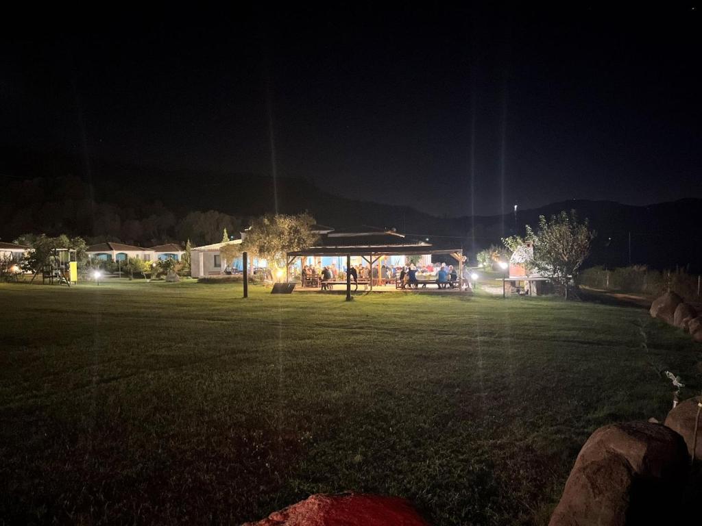 a park at night with a building with lights at Hotel Baia Cea in Bari Sardo