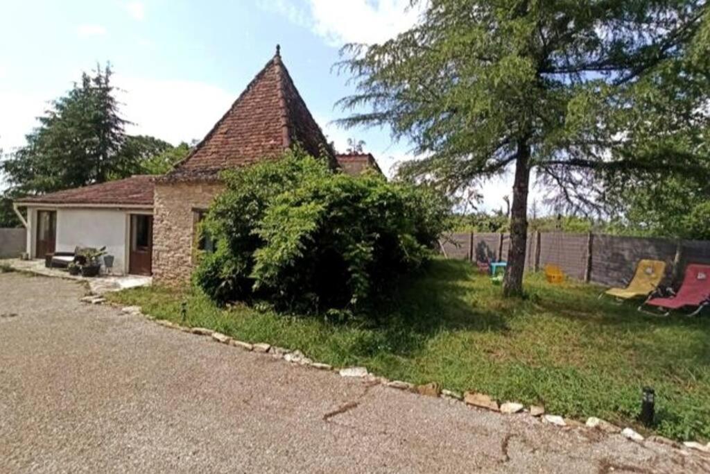 ein Haus mit einem großen Busch im Hof in der Unterkunft Magnifique pigeonnier rénové classé 3 étoiles in Catus