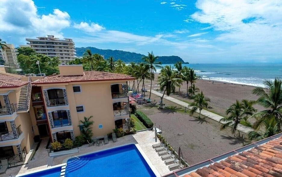 uitzicht op het strand vanaf het balkon van een huis bij BEACHFRONT Condo Bahia Encantada Jaco Beach L1 in Jacó