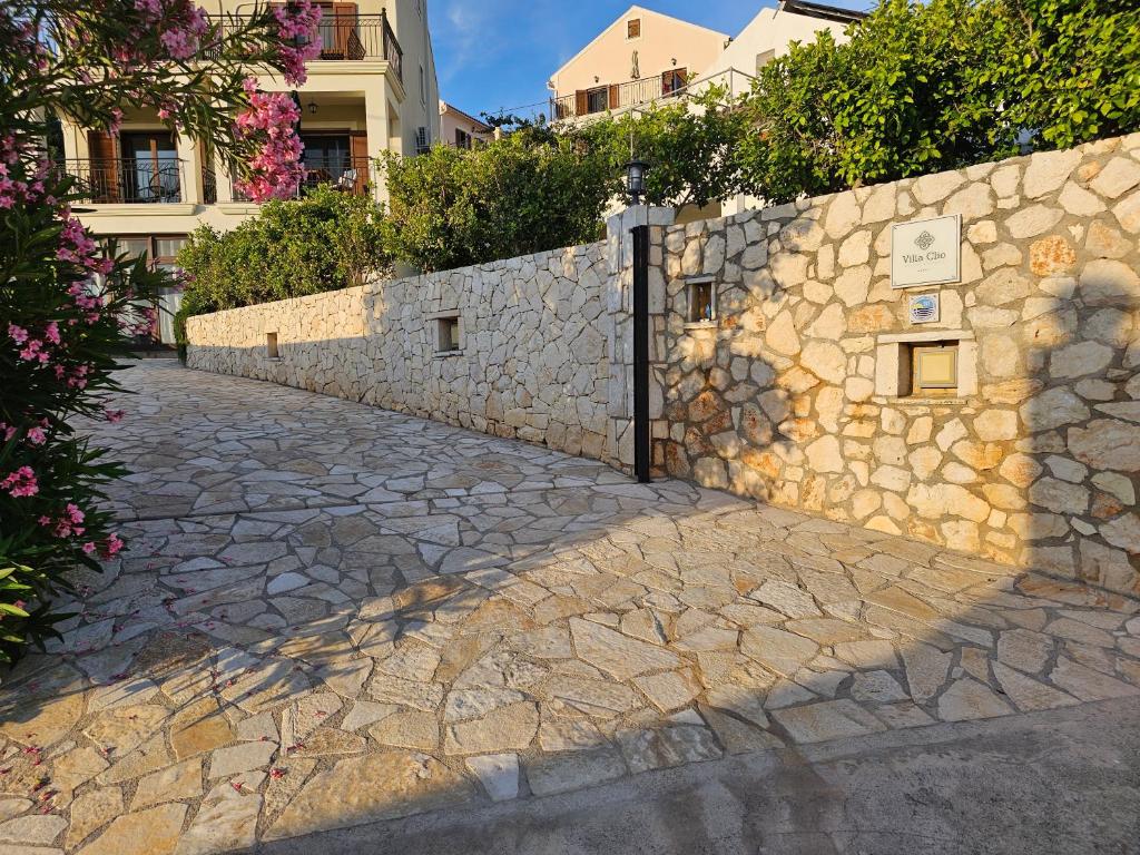 a stone retaining wall next to a stone sidewalk at Villa Clio in Mánganos