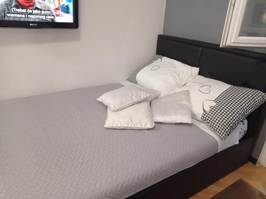 1 cama con 4 almohadas y TV. en Apartment Victoria, en Split