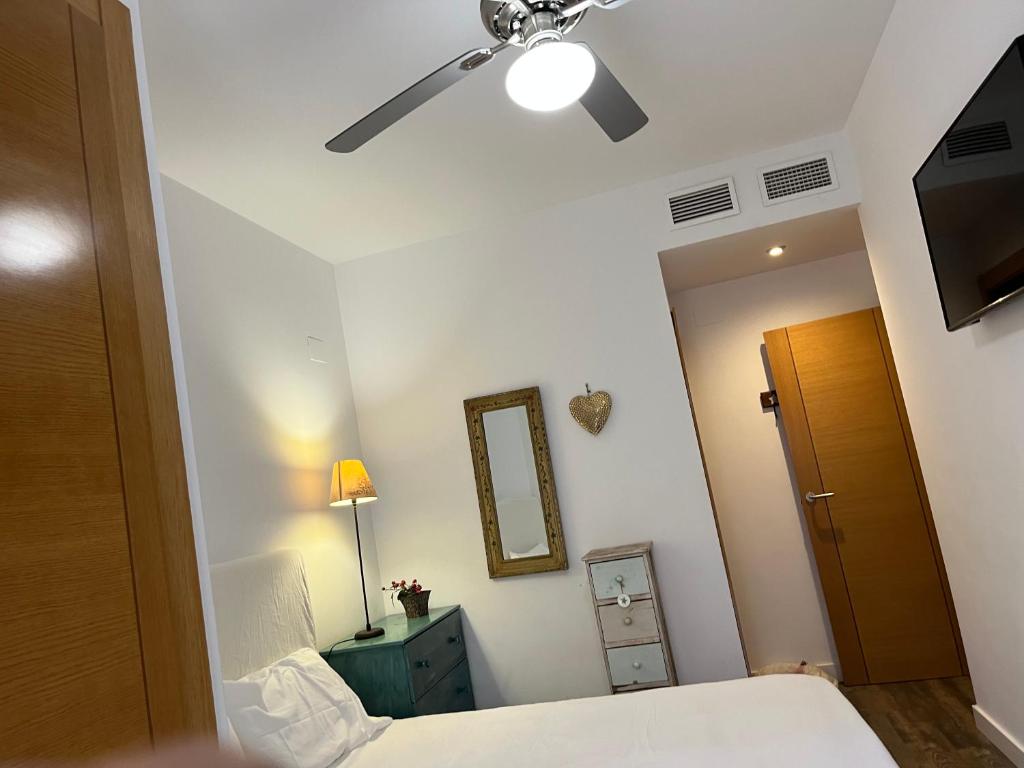 a bedroom with a bed and a ceiling fan at Bonito bajo con gran terraza in San Juan de Alicante