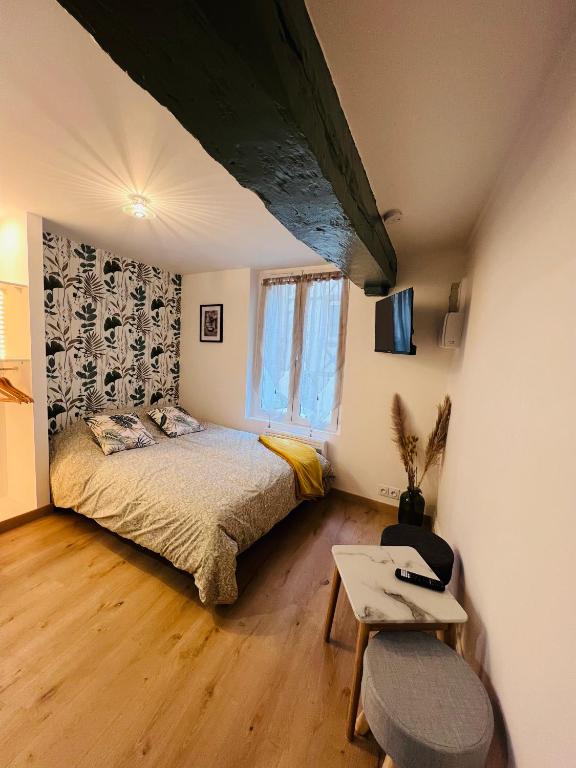 une chambre avec un lit, une table et une fenêtre dans l'établissement Rouen Saint Nicaise, à Rouen