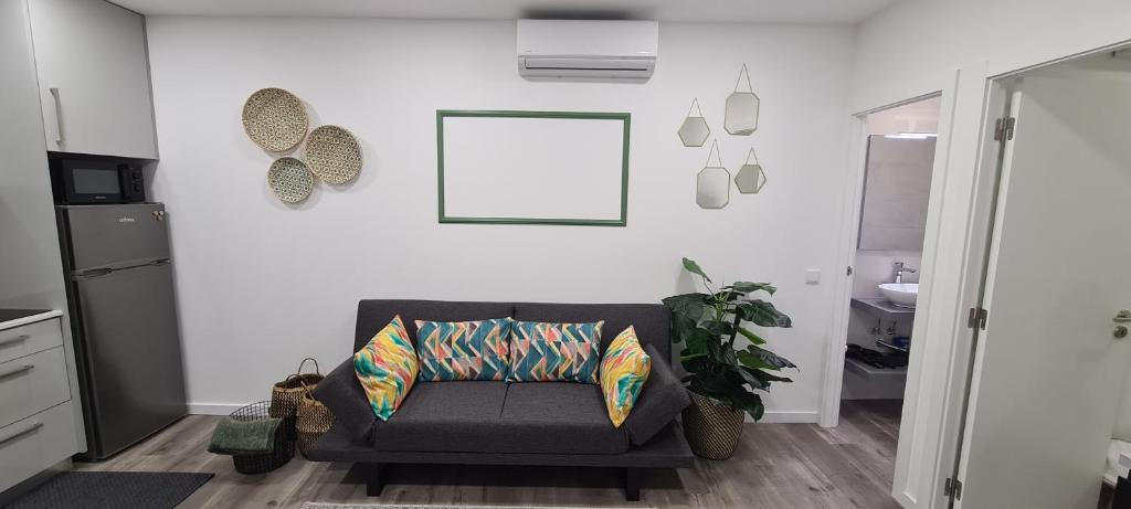 uma sala de estar com um sofá e uma fotografia na parede em Nazaré Apartment 2 na Nazaré