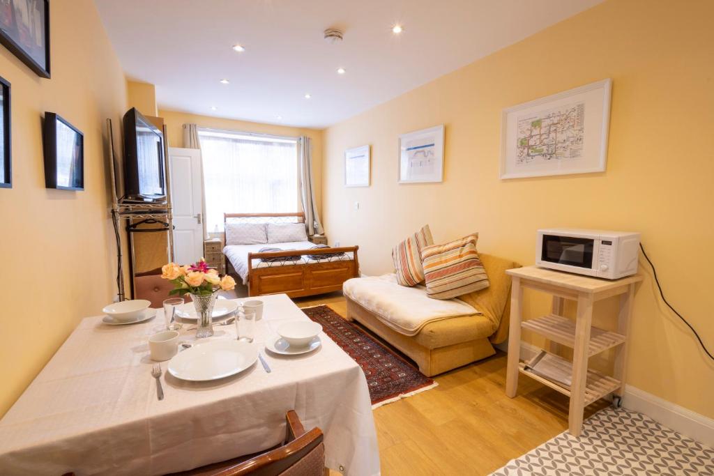 een woonkamer met een tafel en een bank bij London VEGETARIAN Smoke & Pet Free En-suite with EV parking in Stone Grove