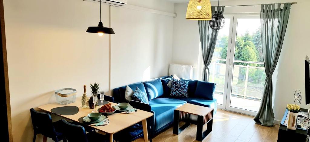 a living room with a blue couch and a table at Zalamo in Kąty Rybackie