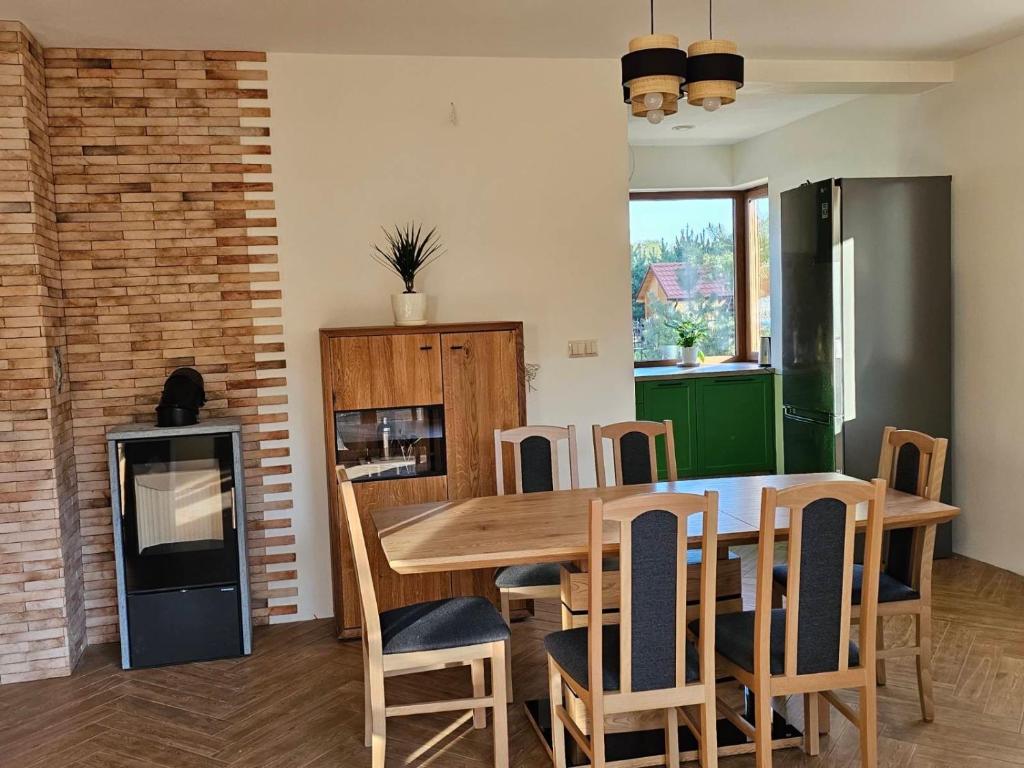 維亞特爾的住宿－Mazurska Sarenka，厨房以及带木桌和椅子的用餐室。