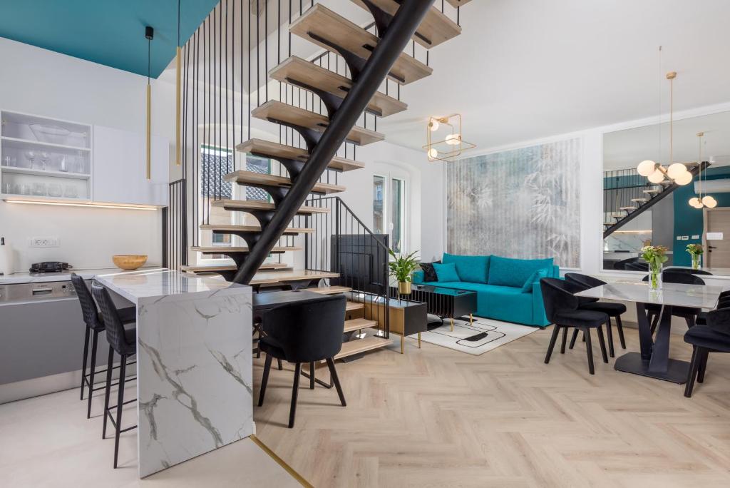 a kitchen and living room with a spiral staircase at Apartments Madeleine in Rijeka