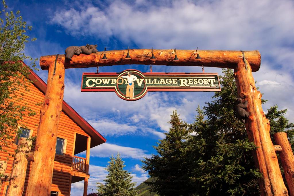 Una señal para una cabaña con un oso encima. en Cowboy Village Resort en Jackson