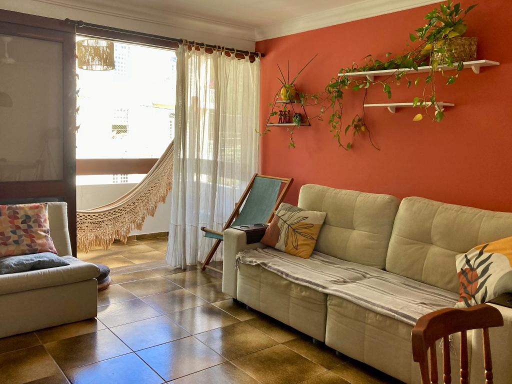 sala de estar con sofá y ventana en Suíte em Luna & Line en Salvador