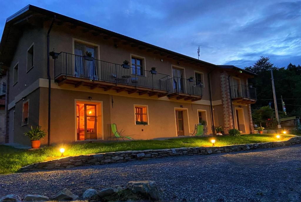 a large house with a balcony and lights in front of it at Ranch Enbrucà in Boves