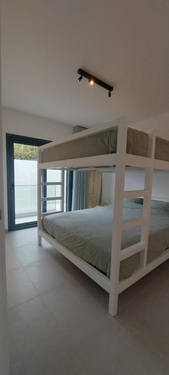 a bedroom with a bunk bed in a white room at Gozo - new luxury villa with private pool in Foz do Arelho