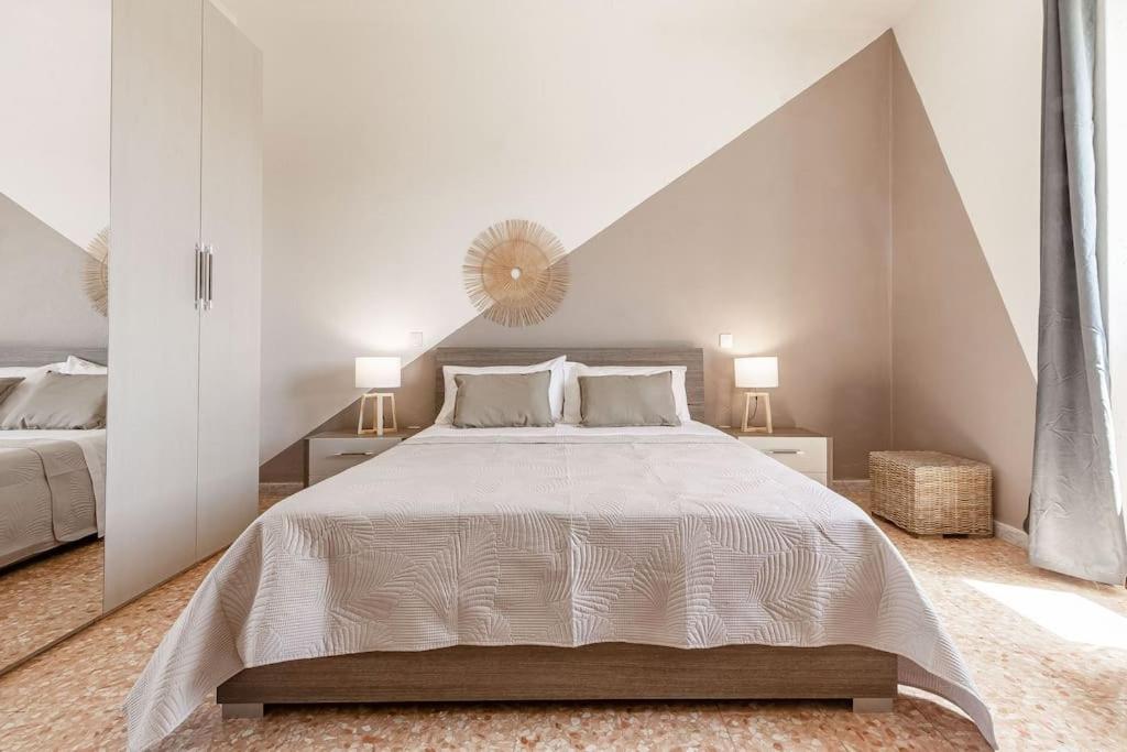 a white bedroom with a large bed and two lamps at Elizabeth Guest House in Arzachena