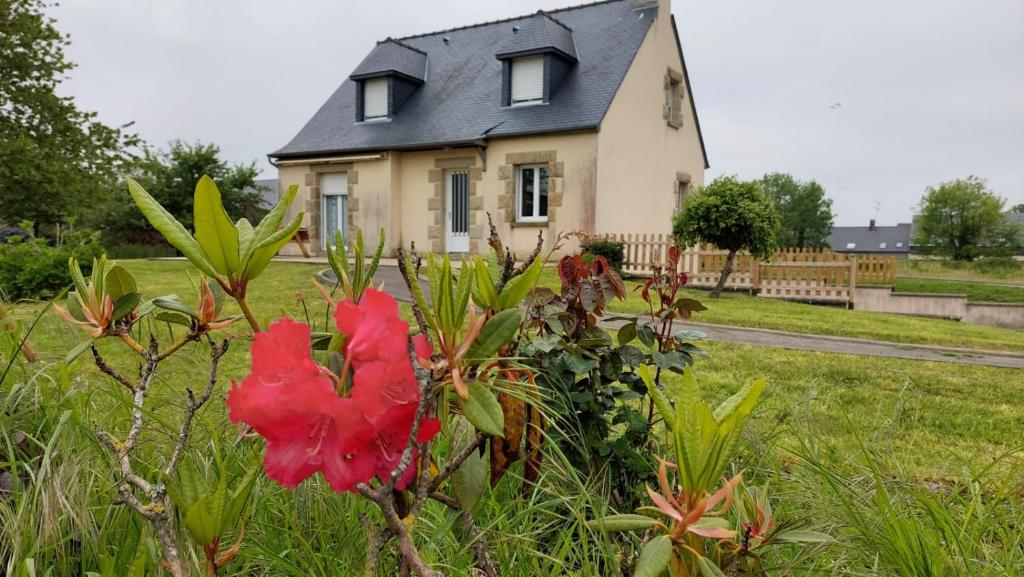 una casa con una flor roja delante de ella en Grande maison de 4 chambres, 9 couchages proche du Mont Saint Michel, en Saint-James