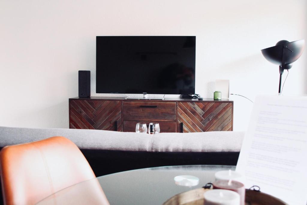 a living room with a television and a table at Apartment Neuss-Düsseldorf Messe in Neuss