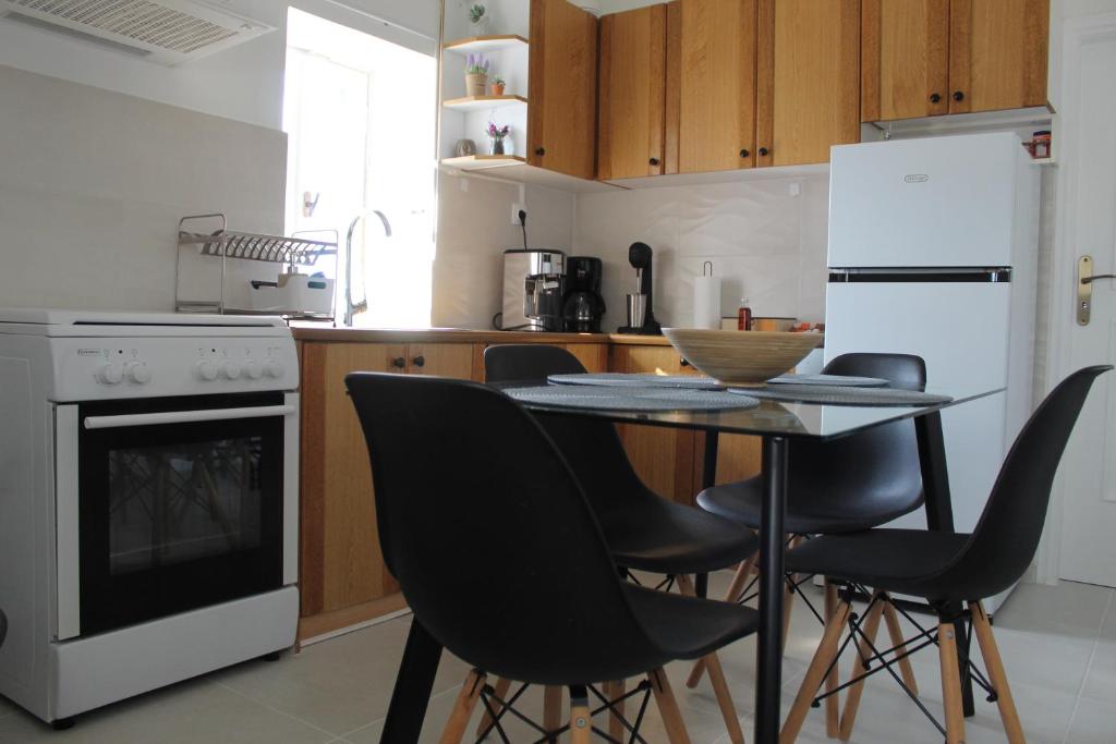 a kitchen with a table and chairs and a refrigerator at Cycladic Villa in Amorgos Island (Maison Shiro) in Arkesíni