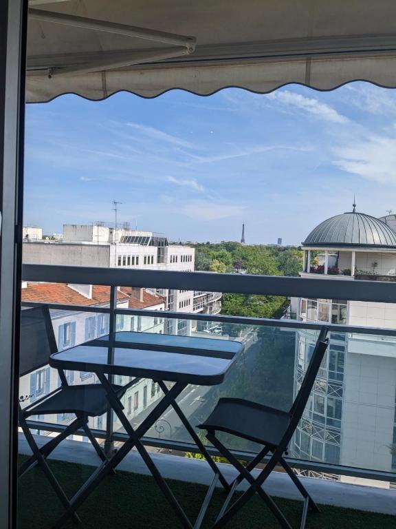 a table and two chairs sitting on a balcony at Superbe STUDIO (28m2) avec terrasse / vue TOUR EIFFEL / PUTEAUX in Puteaux