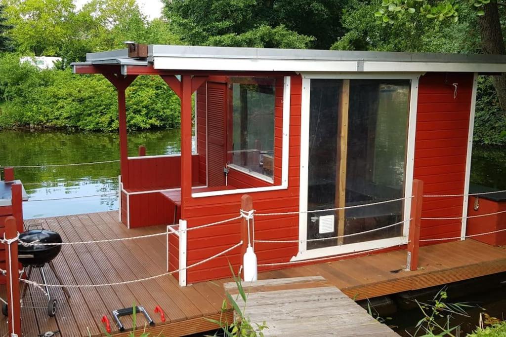 a red cabin on a boat on the water at Floß Casanova in Erkner