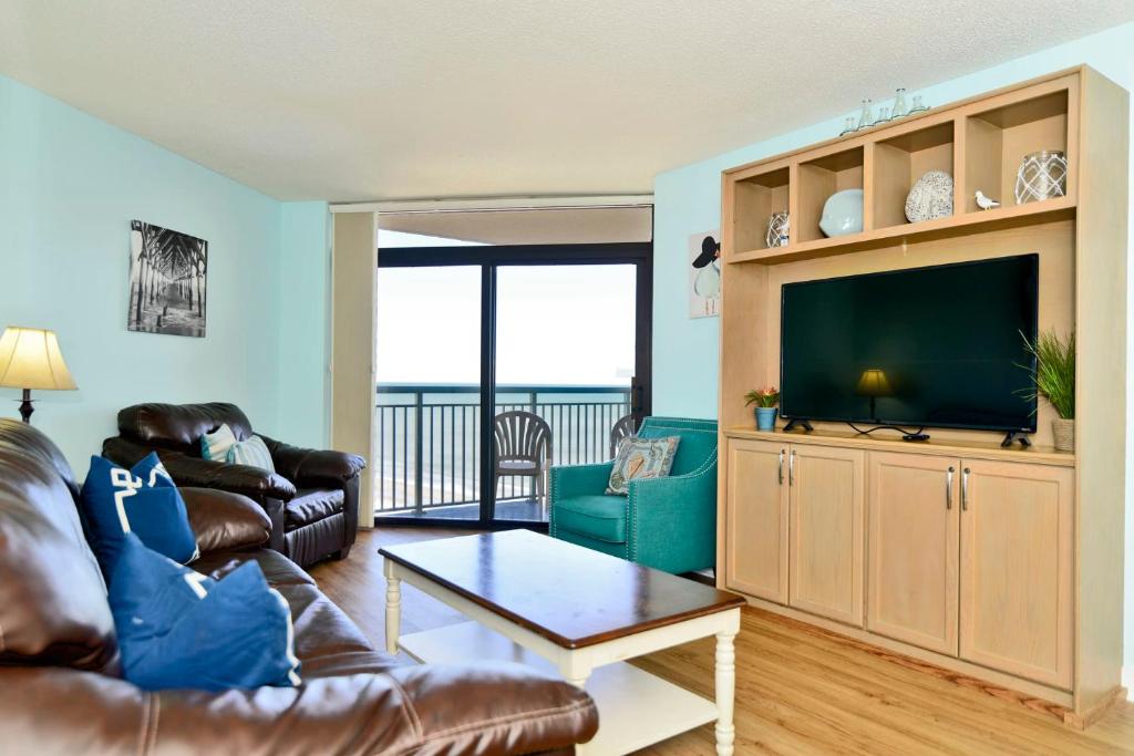 a living room with a couch and a flat screen tv at Paradise Ocean View at Top Resort w Lazy River in Myrtle Beach