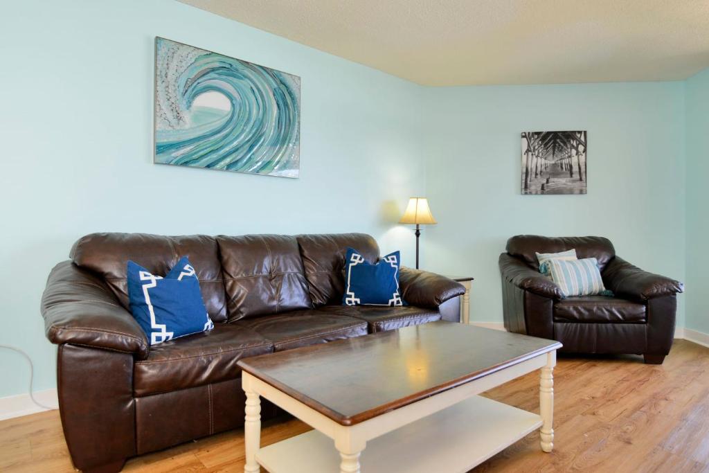 a living room with a leather couch and a coffee table at Paradise Ocean View at Top Resort w Lazy River in Myrtle Beach