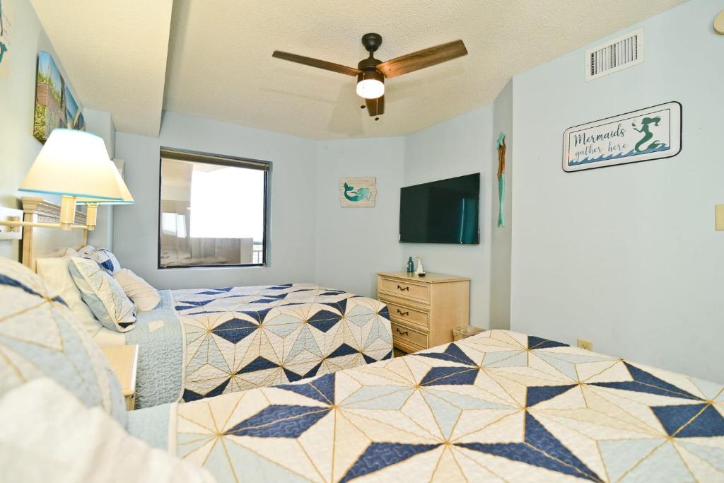 a bedroom with two beds and a ceiling fan at Paradise Ocean View at Top Resort w Lazy River in Myrtle Beach