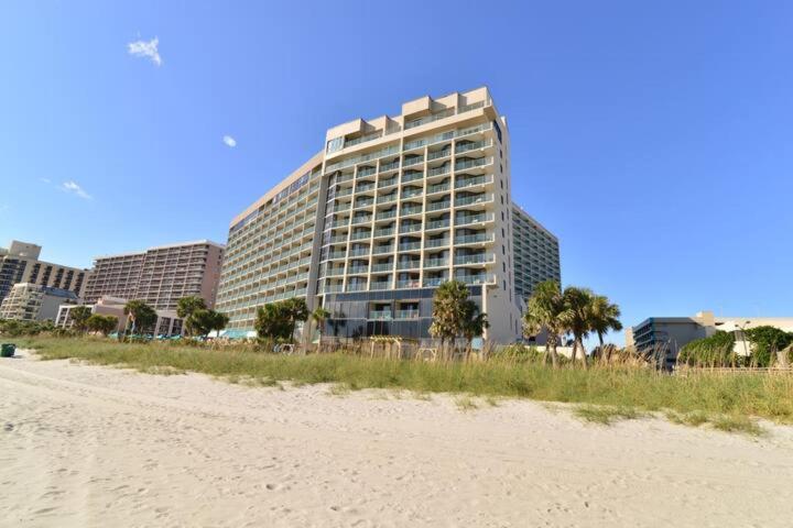 a large building on the beach next to a beach at Paradise Ocean View at Top Resort w Lazy River in Myrtle Beach