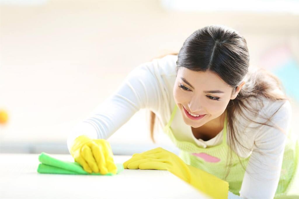 a woman is cleaning a table with a pair of gloves at Paradise Ocean View at Top Resort w Lazy River in Myrtle Beach