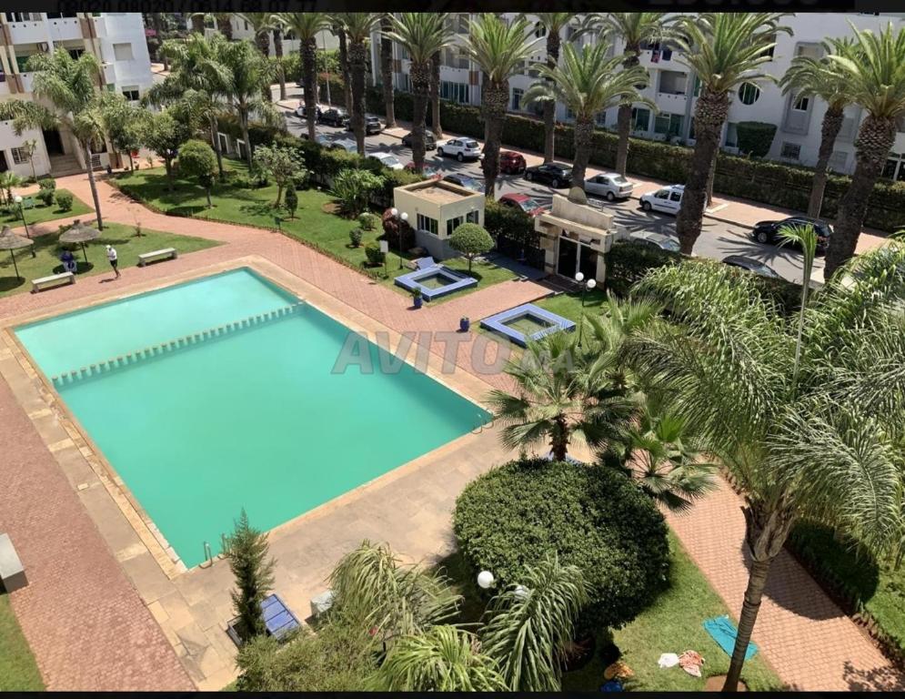 een uitzicht over een zwembad met palmbomen bij Perle sur la mer in Mohammedia