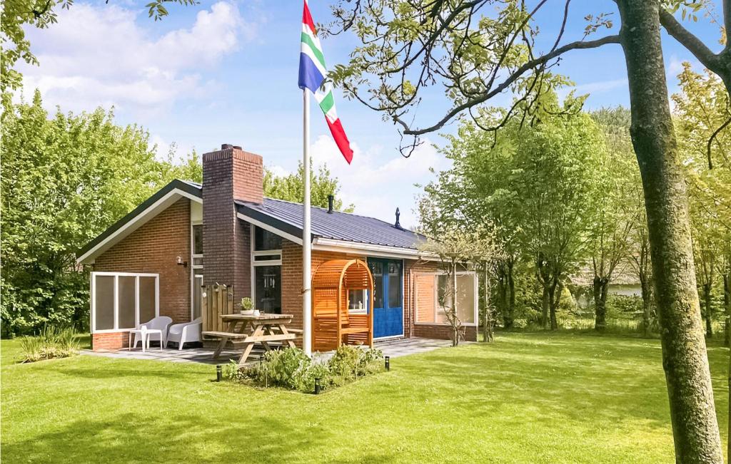 a house with a flag in the yard at Awesome Home In Lauwersoog With Kitchen in Lauwersoog