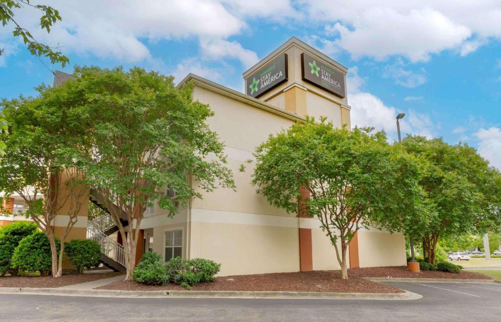 a hotel with trees in front of a building at Extended Stay America Suites - Fayetteville - Owen Dr in Fayetteville